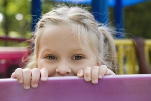 Playful peeking blonde girl